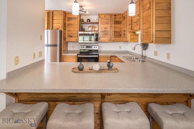 85 Spruce Cone Unit 10, Big Sky, MT 59716 - kitchen featuring appliances with stainless steel finishes, a peninsula, hanging light fixtures, open shelves, and a breakfast bar