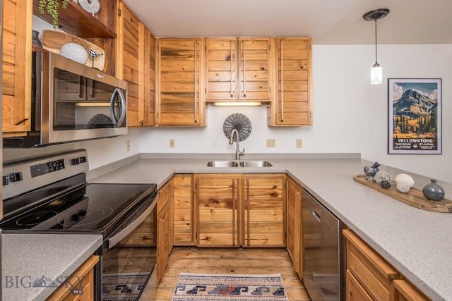85 Spruce Cone Unit 10, Big Sky, MT 59716 - kitchen featuring appliances with stainless steel finishes, light wood-style flooring, decorative light fixtures, and light countertops