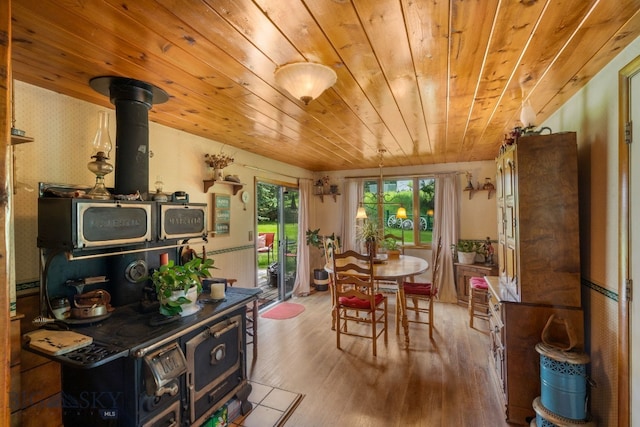 dining room with wooden ceiling, wood-type flooring, and a wood stove