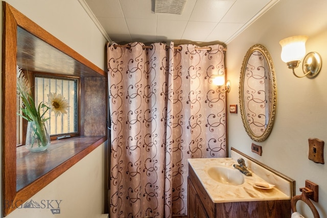 bathroom with curtained shower, vanity, and crown molding