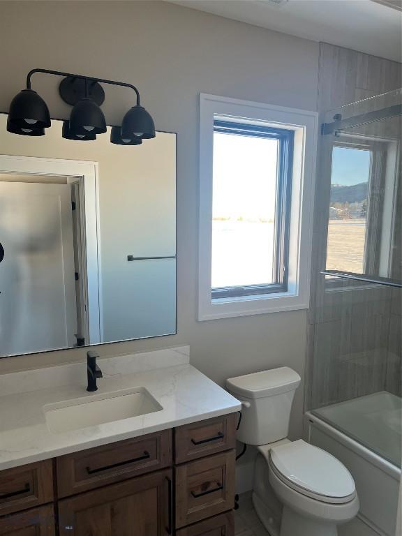 full bathroom with vanity, shower / bath combination with glass door, and toilet