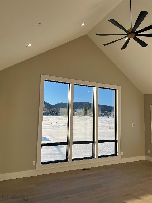 bonus room featuring hardwood / wood-style flooring, ceiling fan, plenty of natural light, and a mountain view