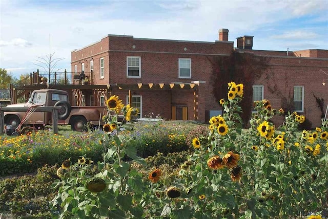 rear view of house featuring brick siding and a chimney