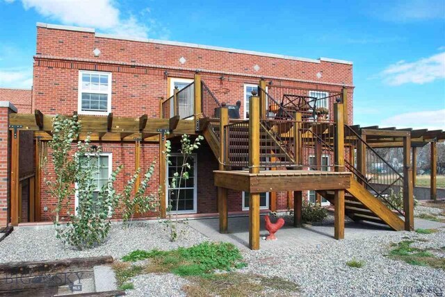 back of house with a deck, a pergola, and a patio area