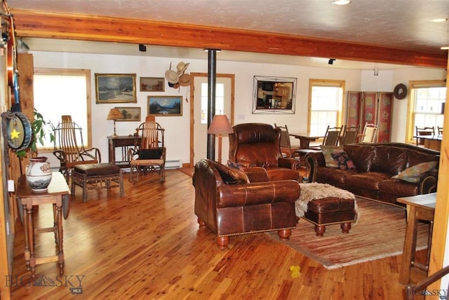 living room featuring plenty of natural light, beamed ceiling, and hardwood / wood-style flooring