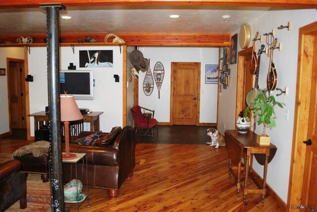 living room featuring beamed ceiling and hardwood / wood-style floors