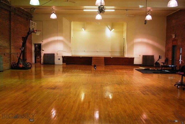 interior space featuring radiator heating unit, hardwood / wood-style floors, and a towering ceiling