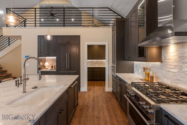 kitchen featuring sink, pendant lighting, wall chimney range hood, and high end appliances