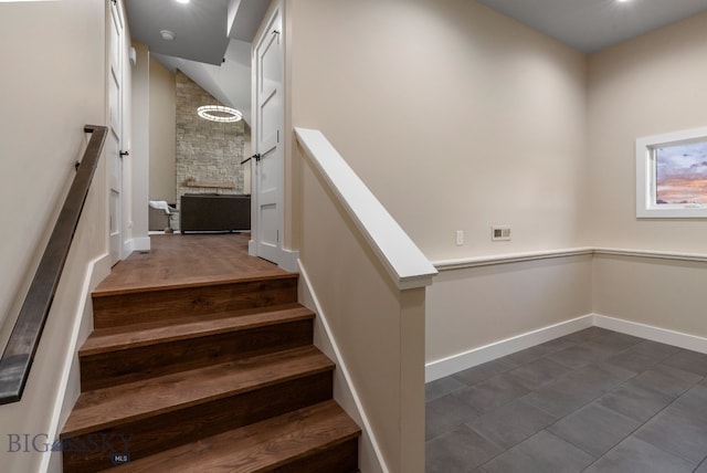 stairway featuring dark hardwood / wood-style flooring and a fireplace