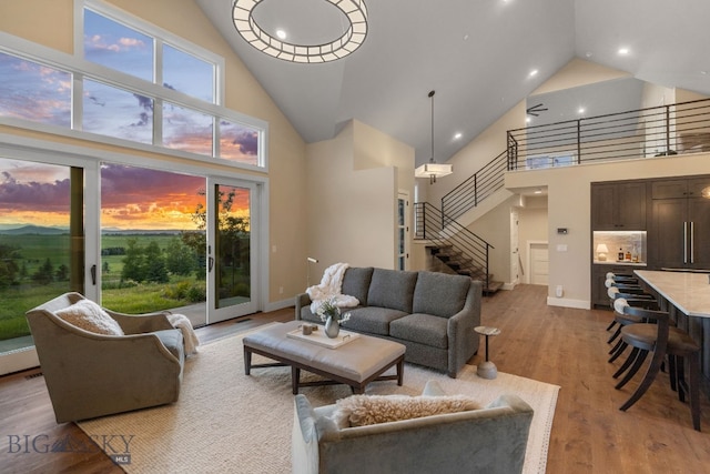 living room with light wood-type flooring and a towering ceiling