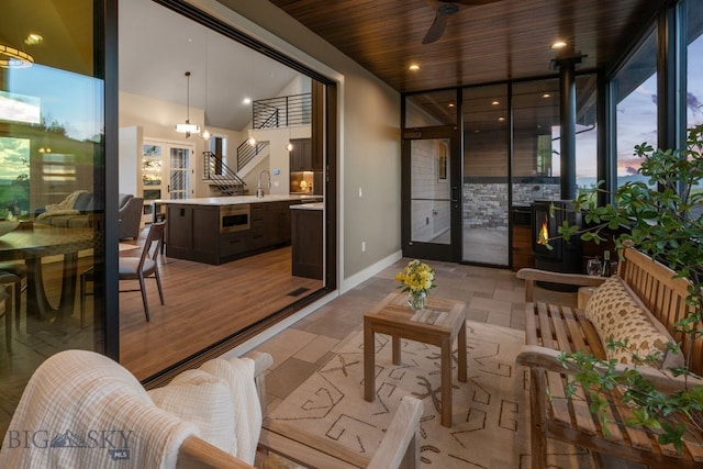 interior space featuring sink, a healthy amount of sunlight, ceiling fan, and wood ceiling