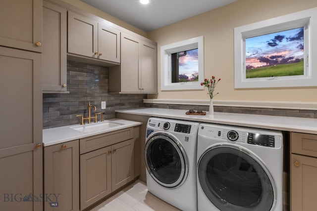 clothes washing area with cabinets, independent washer and dryer, and sink