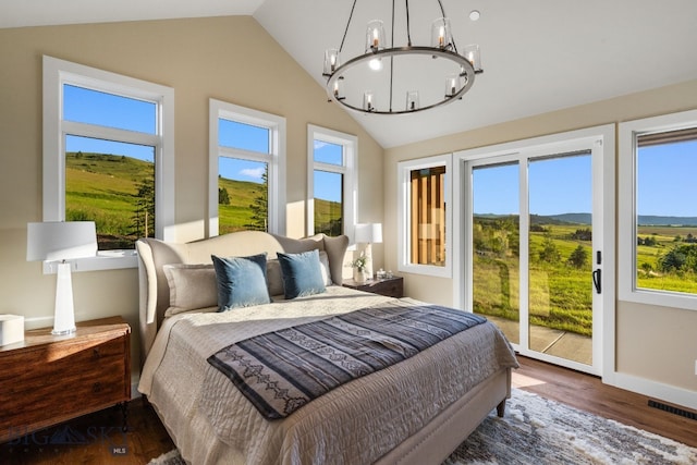 bedroom with access to exterior, a chandelier, dark hardwood / wood-style floors, and lofted ceiling