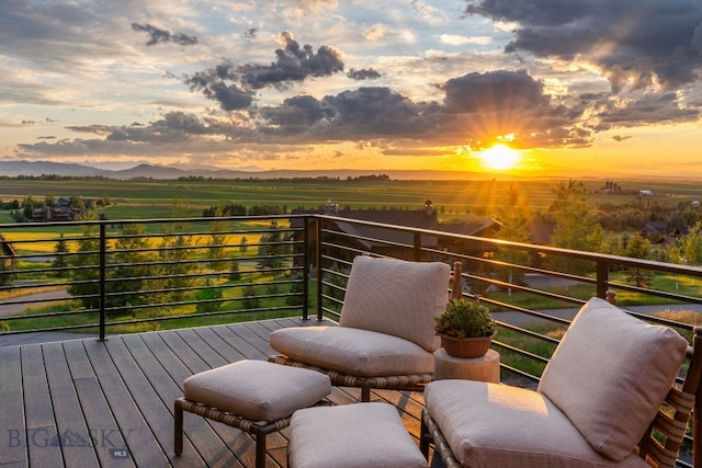 deck at dusk featuring a rural view