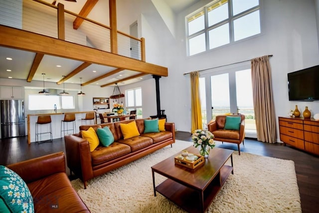 living room featuring dark hardwood / wood-style flooring, a healthy amount of sunlight, beamed ceiling, and sink