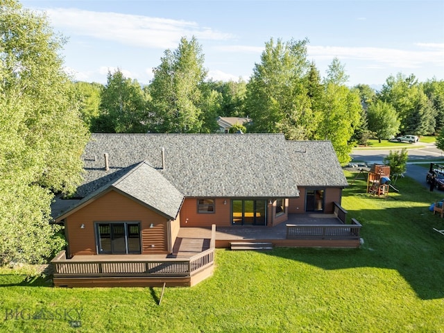 rear view of house featuring a lawn and a deck