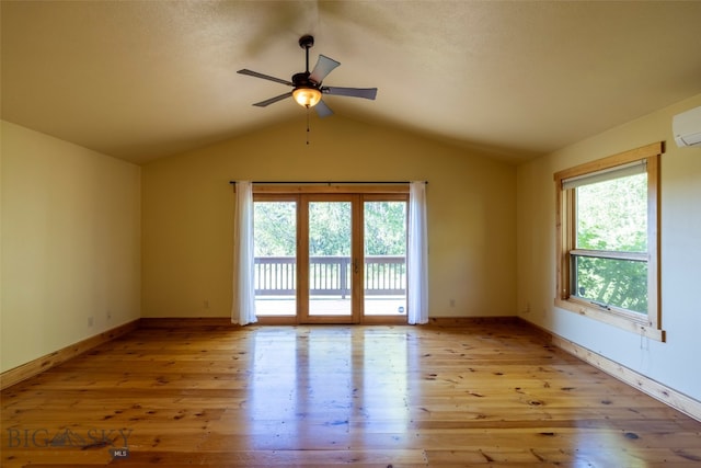 empty room featuring lofted ceiling, a wealth of natural light, light hardwood / wood-style floors, and ceiling fan