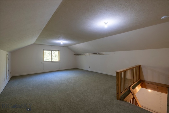 bonus room with carpet flooring, vaulted ceiling, and a textured ceiling