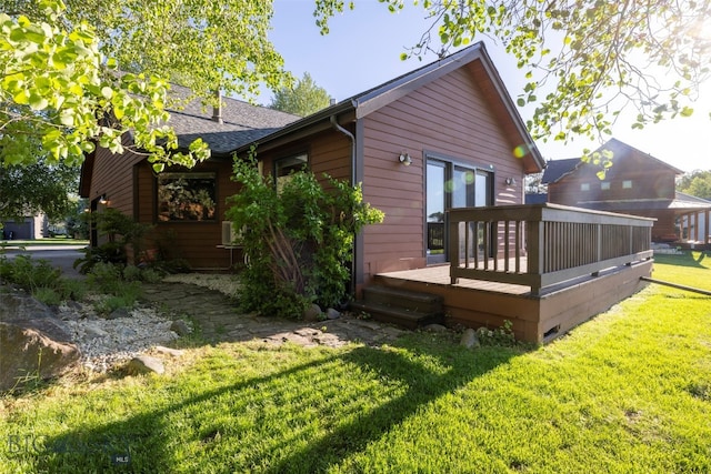 rear view of property with a yard and a deck