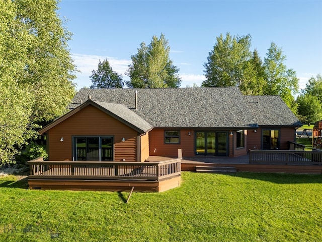 back of property with a wooden deck and a lawn