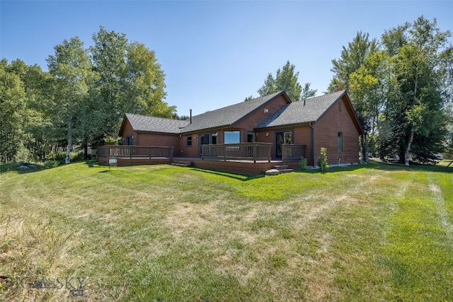 rear view of house featuring a deck and a lawn