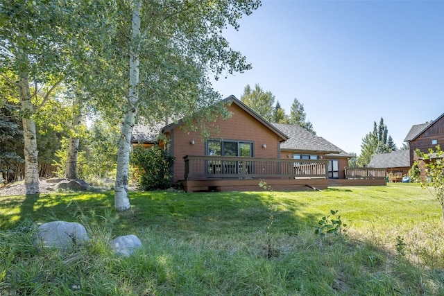 rear view of house featuring a deck and a lawn