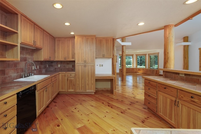 kitchen featuring tasteful backsplash, dishwasher, sink, tile counters, and light wood-type flooring