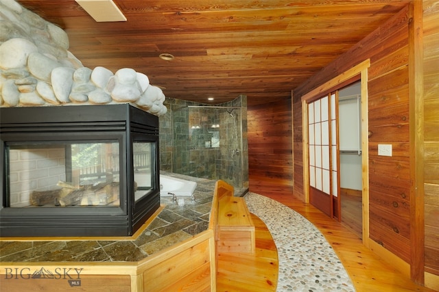 bathroom featuring independent shower and bath, wood-type flooring, wooden ceiling, and wood walls