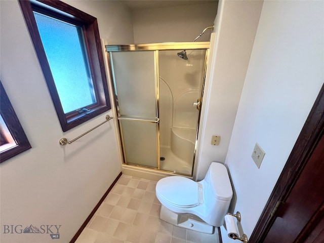 bathroom featuring toilet, tile patterned floors, and walk in shower