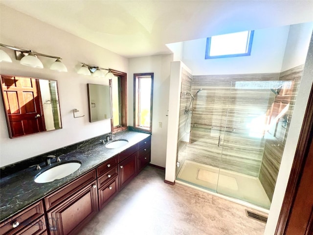 bathroom with dual vanity, walk in shower, and tile patterned flooring