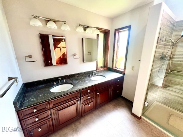 bathroom featuring dual vanity, tile patterned floors, and a tile shower