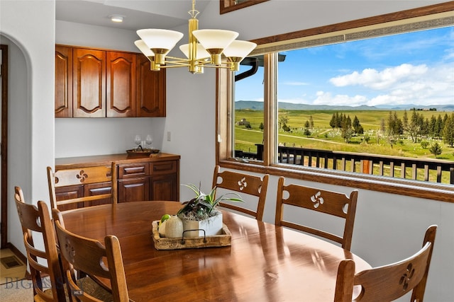 dining area with a rural view and a chandelier