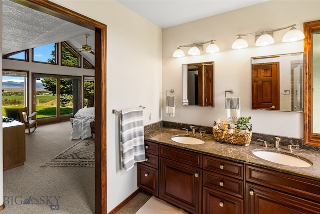 bathroom featuring double vanity and lofted ceiling