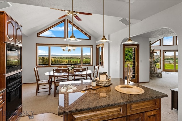 kitchen with oven, a healthy amount of sunlight, light colored carpet, and a kitchen island