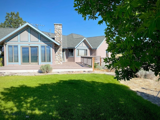 rear view of house with a deck and a lawn