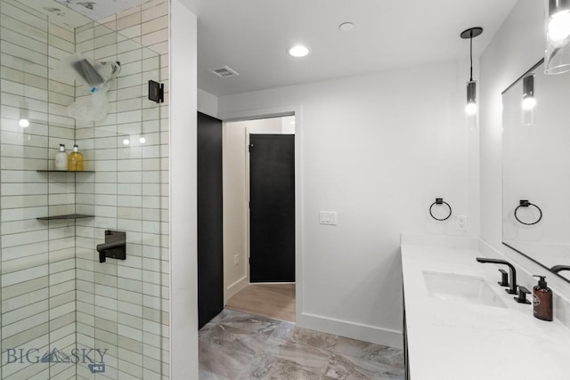 bathroom with vanity and a tile shower