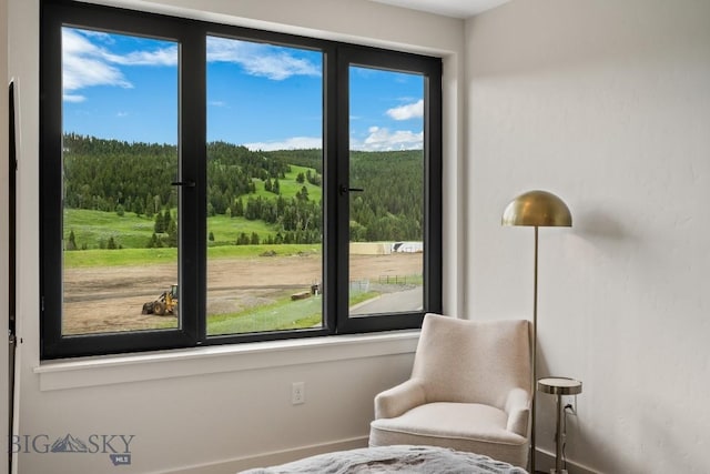 211 Town Center Ave Unit 3G, Big Sky, MT 59716 - sitting room featuring baseboards and a forest view