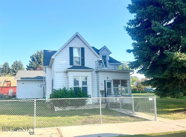 view of front of house with a balcony and a front yard