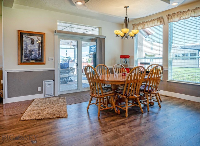 dining room with dark hardwood / wood-style floors, a chandelier, and a textured ceiling