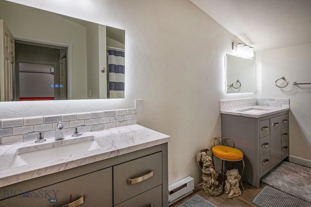 bathroom featuring vanity, backsplash, hardwood / wood-style flooring, and baseboard heating