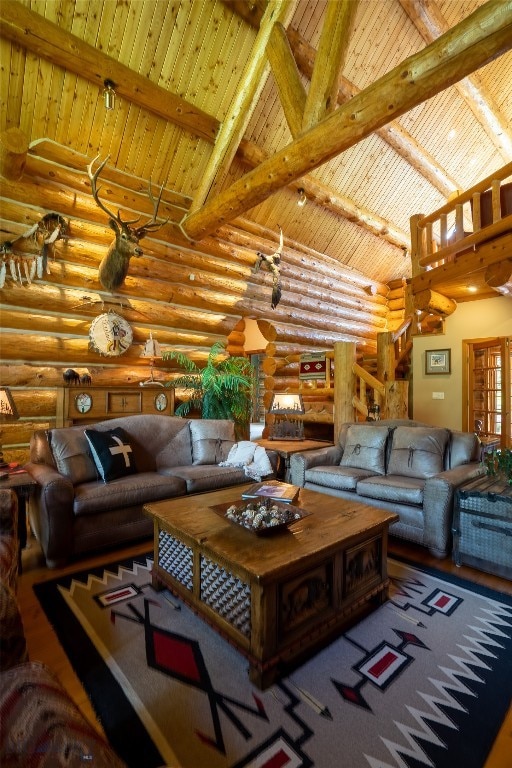 living room with high vaulted ceiling, rustic walls, and beam ceiling