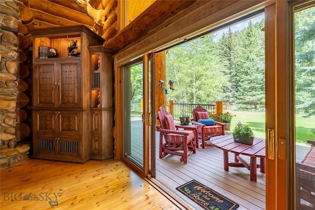 entryway featuring log walls and light hardwood / wood-style floors