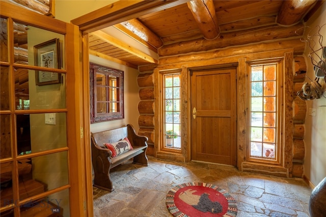 foyer featuring beamed ceiling, wood ceiling, and rustic walls