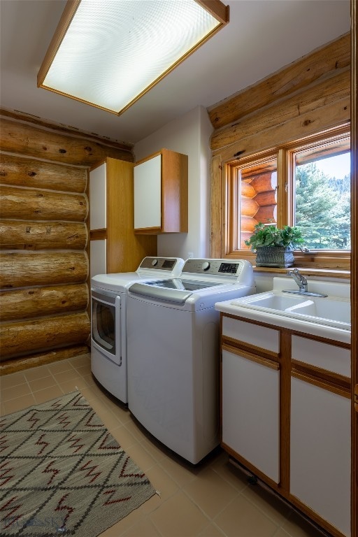 clothes washing area with sink, log walls, separate washer and dryer, cabinets, and light tile patterned floors