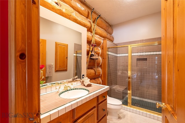 bathroom featuring tile patterned floors, a shower with shower door, toilet, and vanity