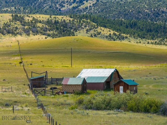 view of stable featuring a rural view and an outbuilding