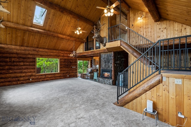 unfurnished living room featuring a fireplace, wooden ceiling, ceiling fan, and a skylight