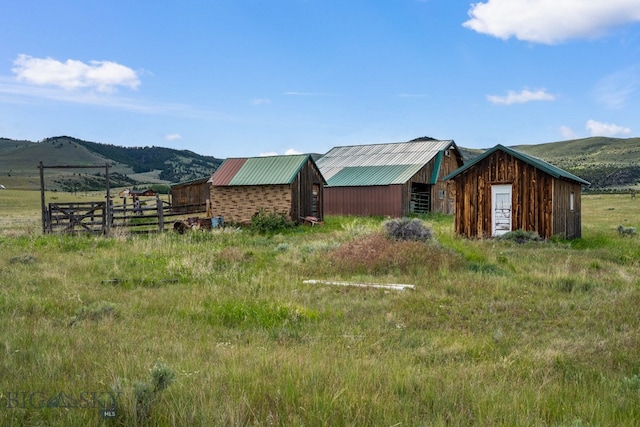 view of yard featuring a mountain view, an outdoor structure, and a rural view