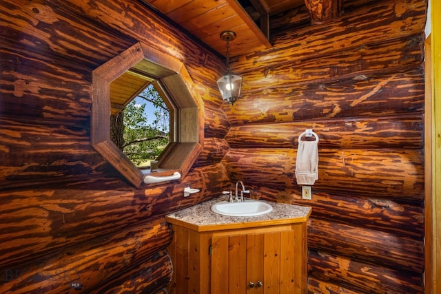 bathroom with wood ceiling, vanity, and wooden walls