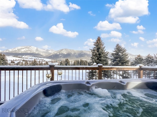 exterior space featuring a mountain view and a hot tub